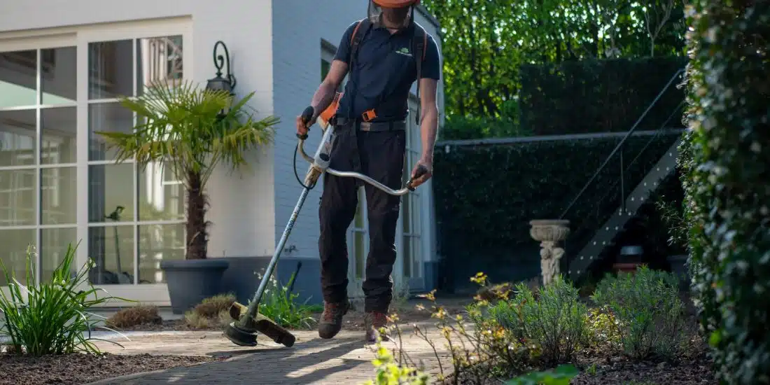 man in black t-shirt and blue denim jeans holding shovel